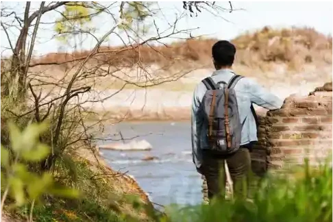 Persona con mochila junto a un río